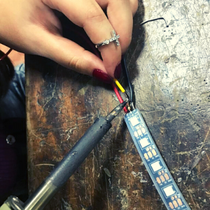 Aluna soldando um circuito em aula de tecnologia do 10o ano